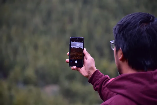 young guy, cellular, taking photo, smartphone, camera. Budget for micro influencer marketing commercial opportunities